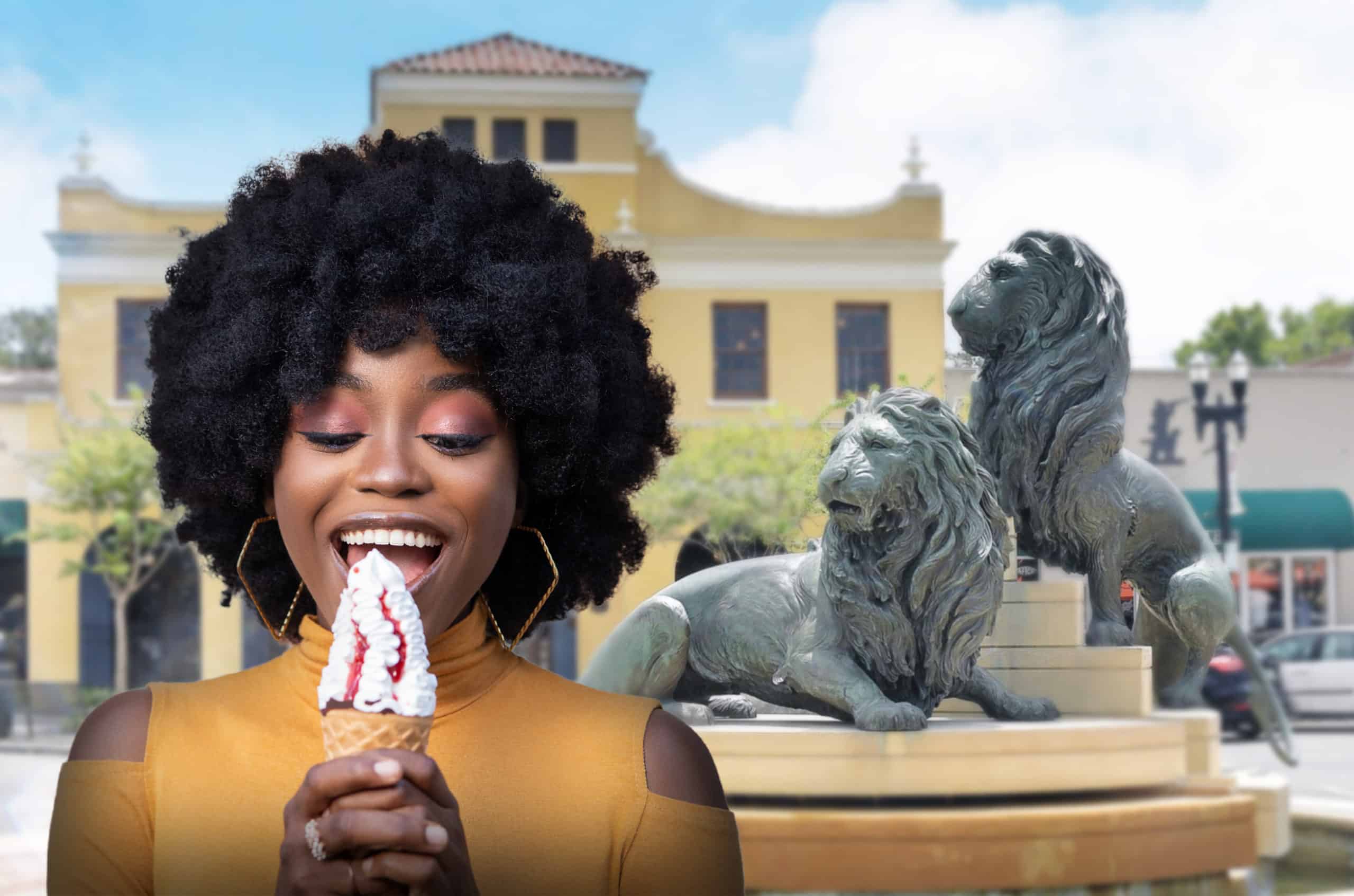 Beautiful black woman enjoys a San Marco Dreamette strawberry vanilla soft serve ice cream cone in San Marco Square near the lion statue in Balis Park