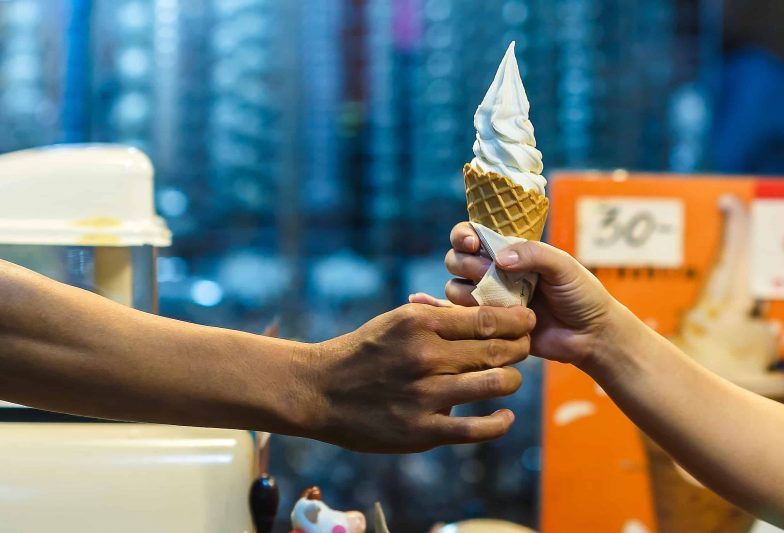 Two hands holding a delicious vanilla soft serve ice cream waffle cone in San Marco Dreamette in Jacksonville Florida the best ice cream in Florida